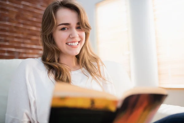 Mulher sorridente lendo um livro — Fotografia de Stock