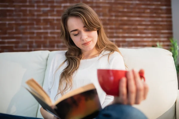 Орієнтована жінка читає книгу під час пиття — стокове фото