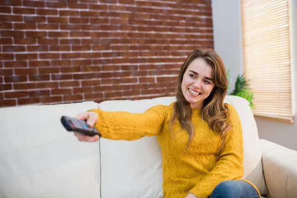 Vrouw met afstandsbediening op Bank — Stockfoto