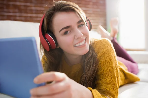 Uśmiechający się ładny kobieta słuchania muzyki z jej tabletki — Zdjęcie stockowe