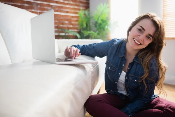 Pretty woman sitting on the floor using laptop — Stock Photo, Image