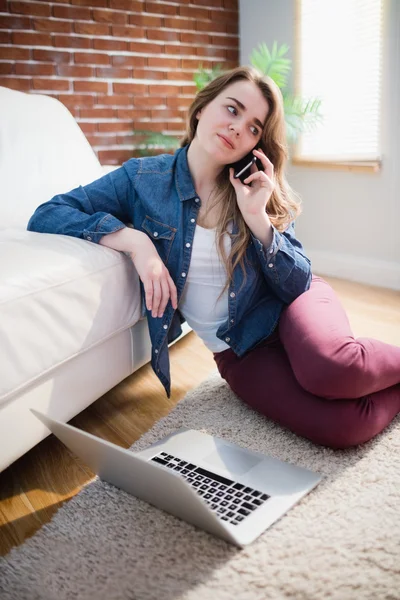 Hübsche Frau, die auf dem Boden sitzt und ruft — Stockfoto