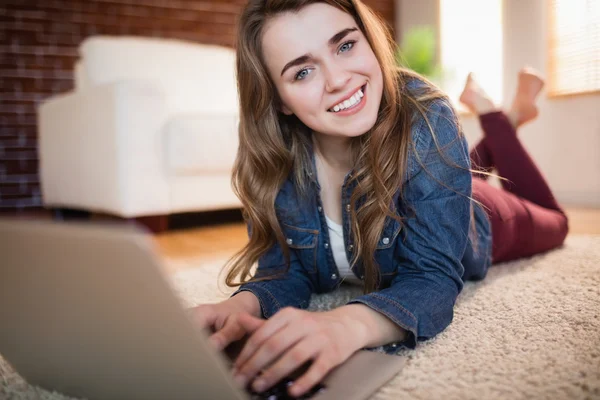 Bella donna sdraiata sul divano utilizzando il computer portatile — Foto Stock