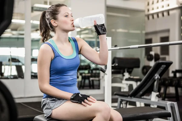 Fit brunett på bänken dricksvatten — Stockfoto