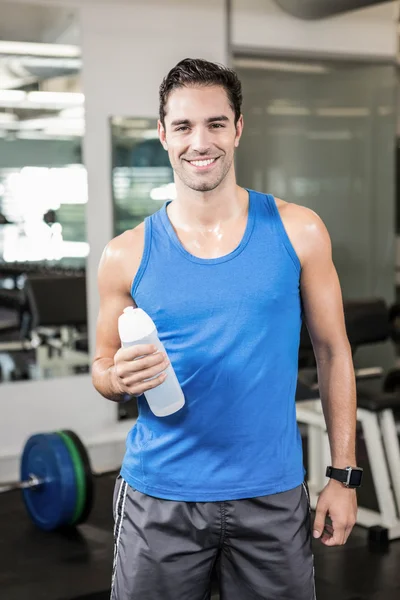 Homme souriant tenant une bouteille d'eau — Photo