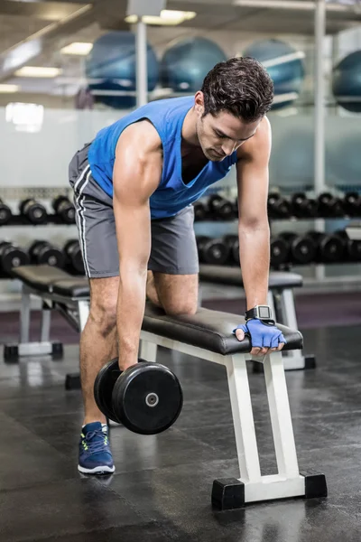 Hombre guapo levantando pesas en el banco — Foto de Stock