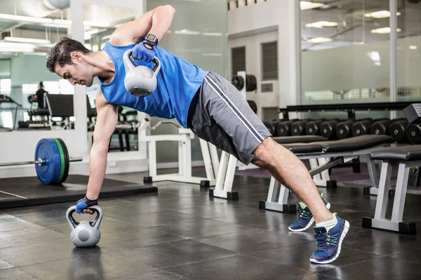 Svalnatý muž dělá cvičení s kettlebells — Stock fotografie