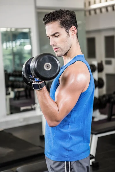 Muscular man lifting dumbbell — Stock Photo, Image