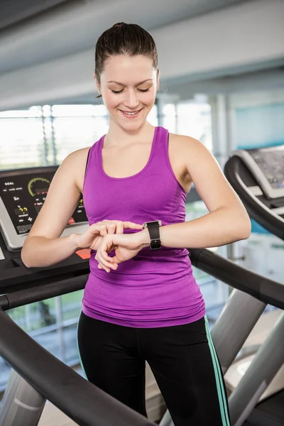 Donna in forma sorridente utilizzando smartwatch — Foto Stock