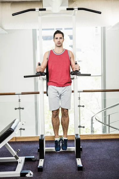 Hombre musculoso haciendo tire hacia arriba — Foto de Stock