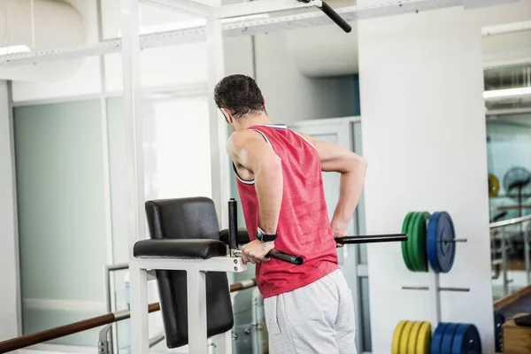 Hombre musculoso haciendo tire hacia arriba — Foto de Stock