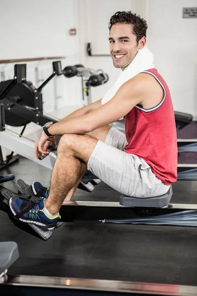 Muscular man on rowing machine — Stock Photo, Image
