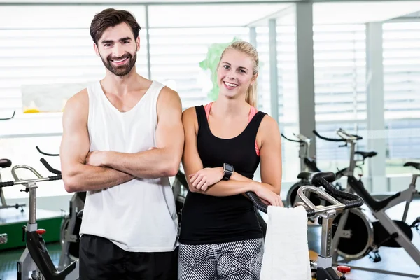 Pareja en forma sonriendo a la cámara con los brazos cruzados — Foto de Stock