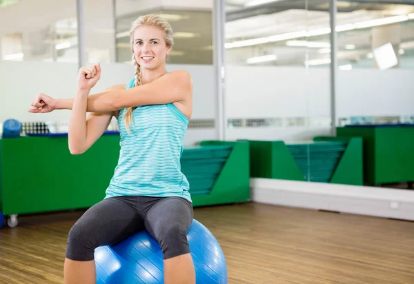 Fitte Frau dehnt sich und sitzt auf Gymnastikball — Stockfoto