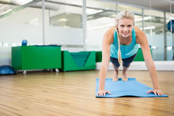 Fit blonde planking op mat — Stockfoto