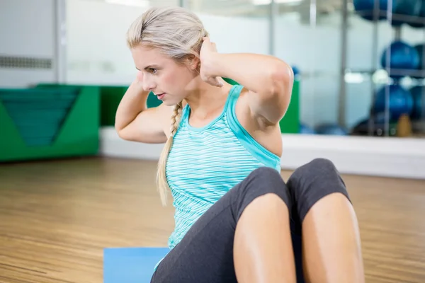 Fitte Blondine beim Sitzen auf Matte — Stockfoto