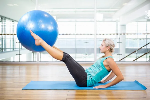 Bacaklar fitness topu ile tutarak mat formda sarışın — Stok fotoğraf