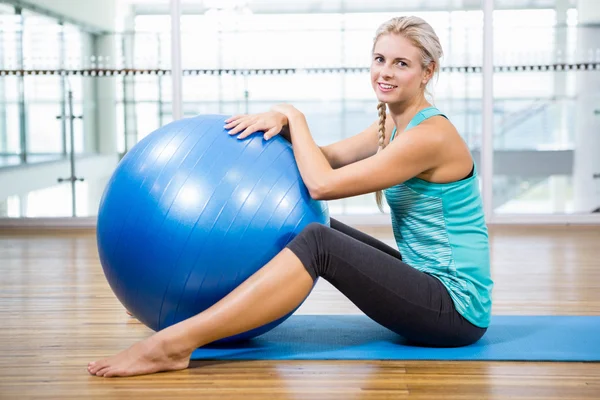 Vältränad blondin på matta poserar med fitness boll — Stockfoto