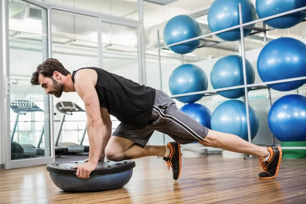 Homme sérieux faisant de l'exercice avec la balle bosu — Photo