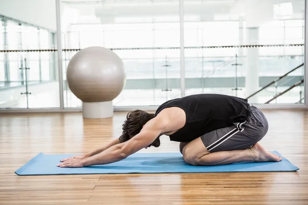 Handsome man doing yoga on mat — Stock Photo, Image