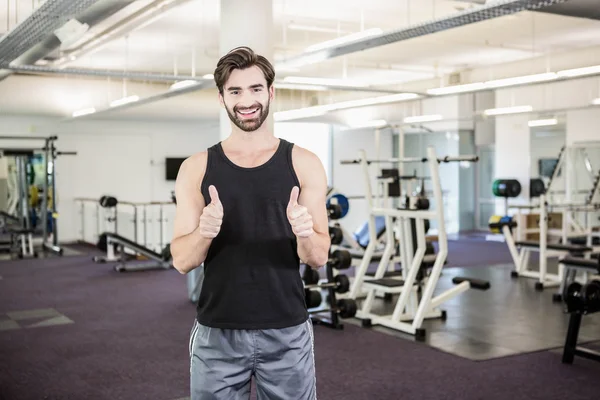 Uomo sorridente mostrando pollici in su — Foto Stock