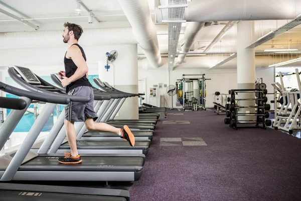Handsome man running on treadmill — Stock Photo, Image