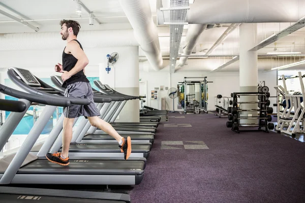 Hombre guapo corriendo en la cinta — Foto de Stock