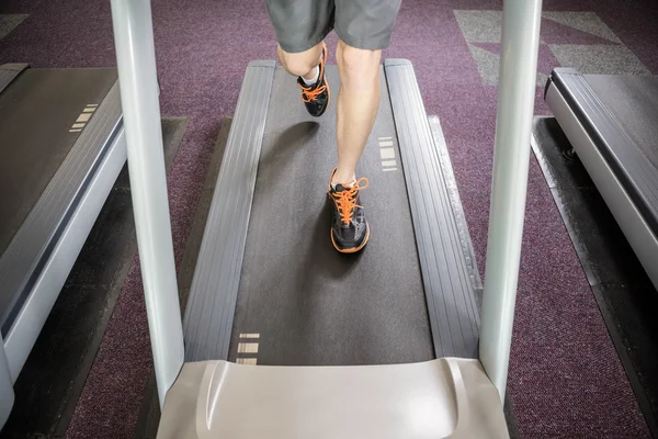 Lower section of man running on treadmill — Stock Photo, Image