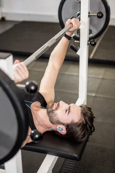 Muskulös man lyfta skivstång på bänk — Stockfoto