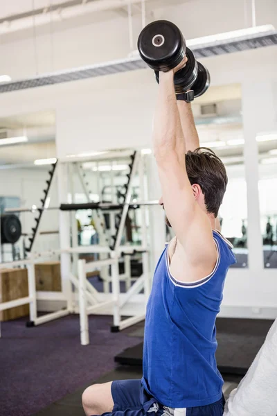 Muscular hombre levantando pesas en banco — Foto de Stock