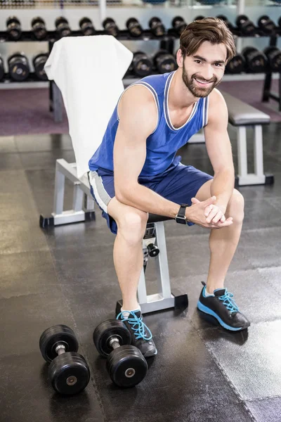 Hombre sonriente sentado en el banco — Foto de Stock