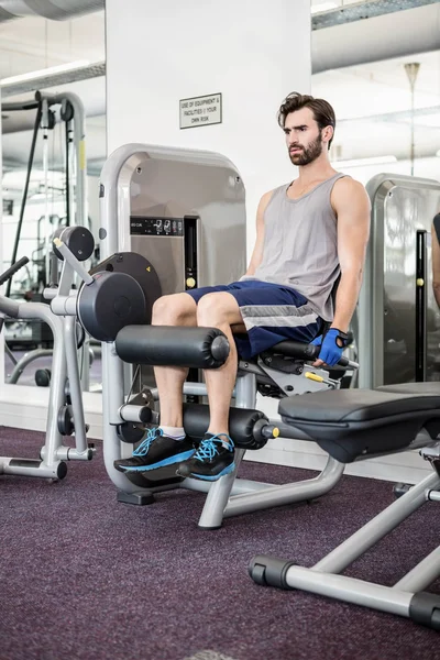 Fokussierte Mann mit Gewichten Maschine für Beine — Stockfoto