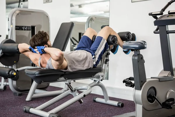 Hombre haciendo abdominales crujidos en el banco — Foto de Stock