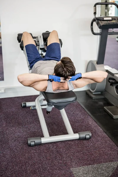 Man doing abdominal crunches on bench — Stock Photo, Image