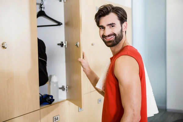 Smiling man opening locker — Stock Photo, Image