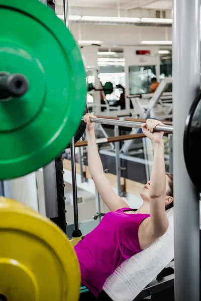 Fit woman lifting the barbell bench press — Stock Photo, Image