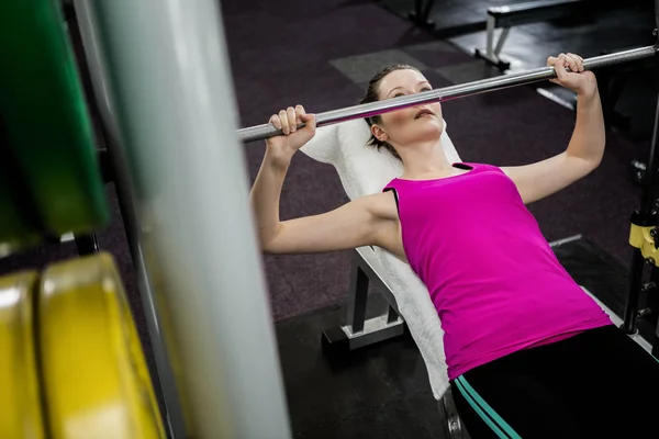 Fit woman lifting the barbell bench press — Stock Photo, Image