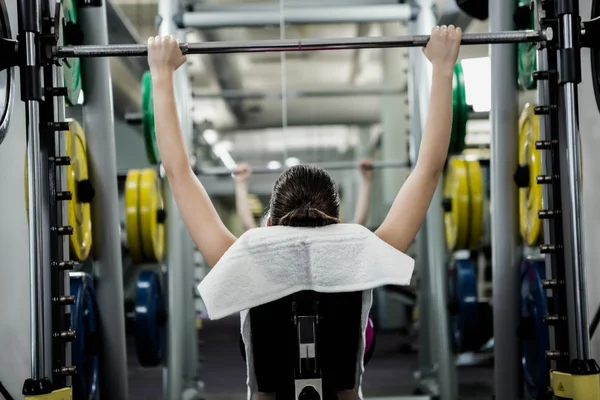 Fit woman lifting the barbell bench press — Stock Photo, Image