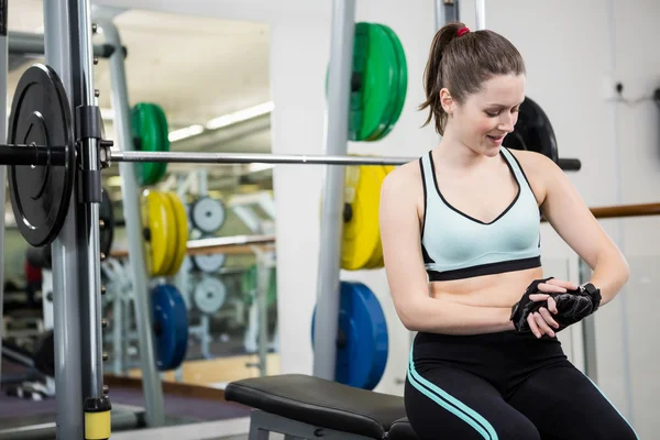 Lachende vrouw zittend op barbell bench — Stockfoto