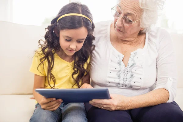 Geconcentreerde kleindochter tablet met oma — Stockfoto