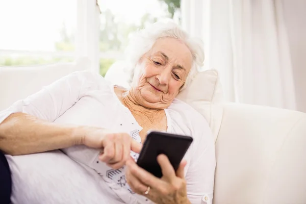 Elderly woman using her smartphone — Stock Photo, Image