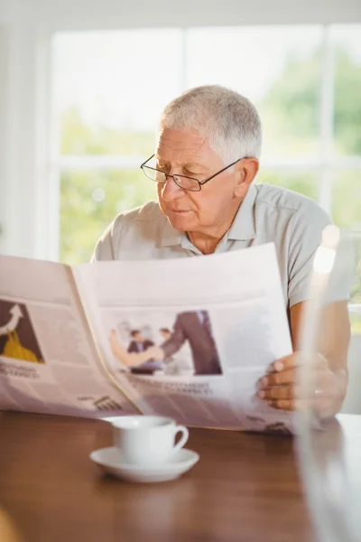 Enfocado hombre mayor leyendo periódico — Foto de Stock