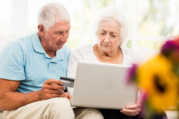 Focalizzato coppia anziana utilizzando il computer portatile — Foto Stock
