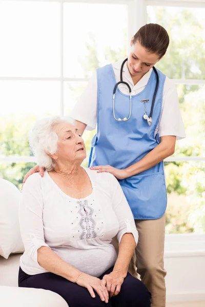 Nurse taking care of sick elderly woman — Stock Photo, Image