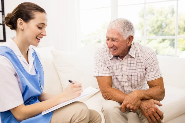 Nurse taking care of sick elderly patient — Stock Photo, Image