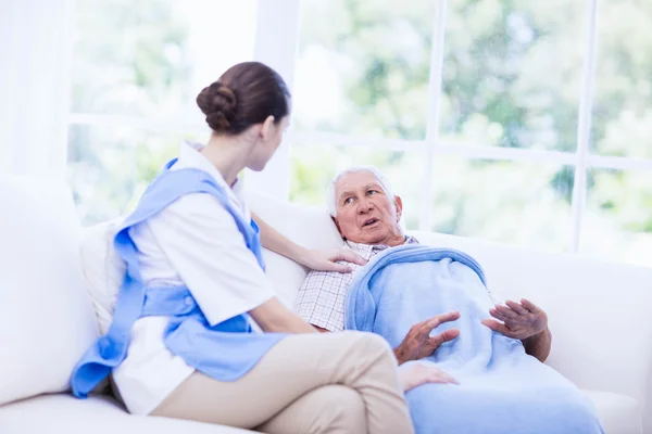 Krankenschwester kümmert sich um kranken alten Patienten — Stockfoto