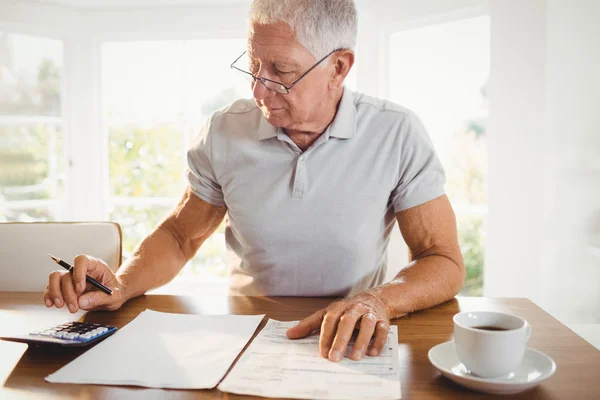 Oroliga äldre man med skattedokument — Stockfoto