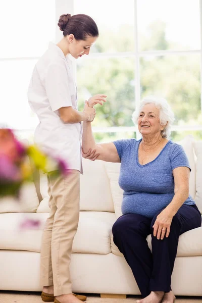 Fisioterapeuta cuidando a paciente anciano enfermo — Foto de Stock