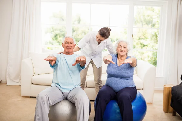 Physiotherapist taking care of sick elderly patients — Stock Photo, Image