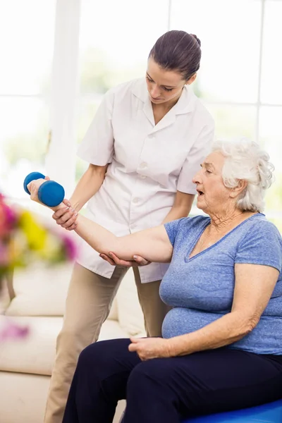 Fisioterapeuta cuidando de paciente idoso doente — Fotografia de Stock